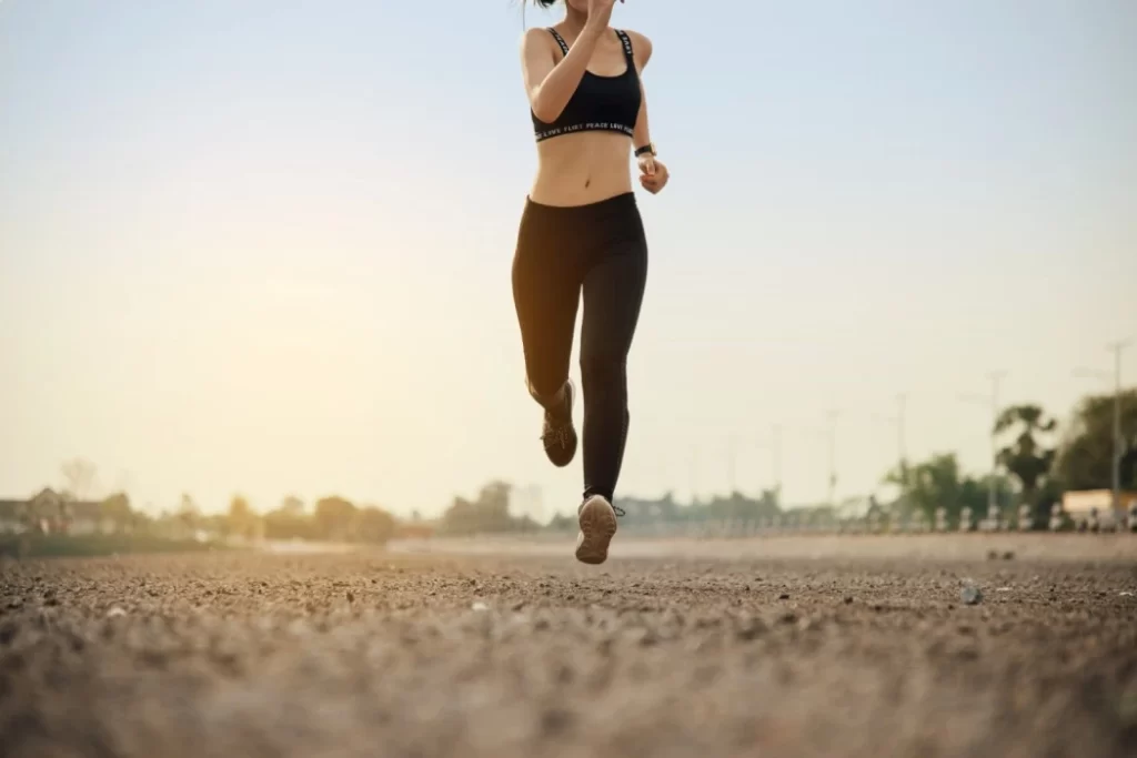 Woman running outdoors, following the 10 Percent Rule to improve her running performance and prevent injury.