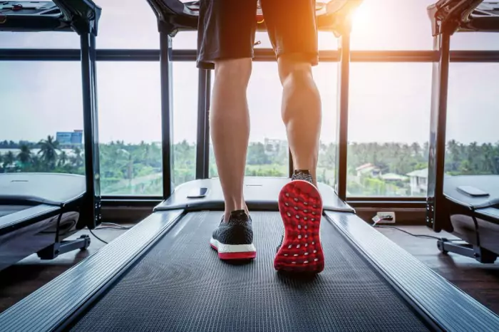 Man running on a treadmill at the gym.