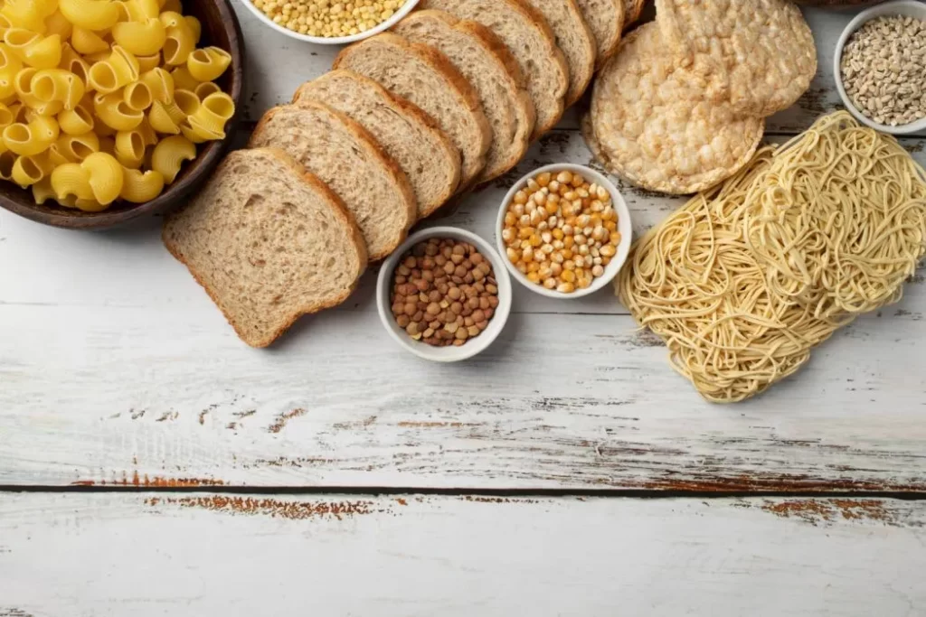 Various carb-rich foods like pasta, bread, and fruits to fuel runners for marathon training.